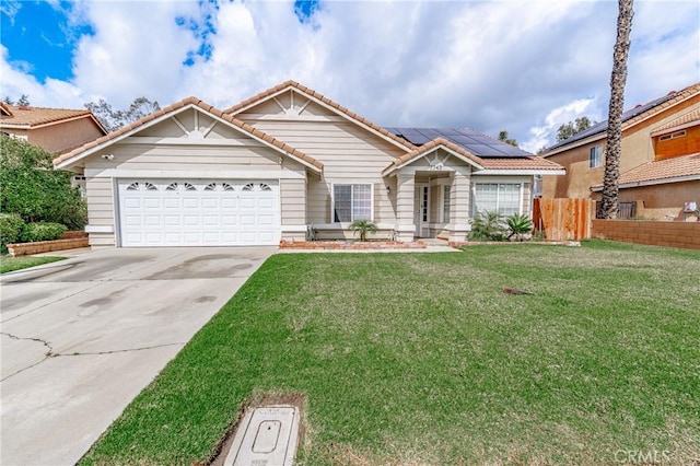 view of front of house featuring fence, driveway, solar panels, a garage, and a tile roof