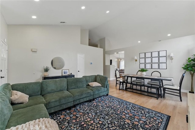 living area with recessed lighting, visible vents, high vaulted ceiling, and light wood-style flooring