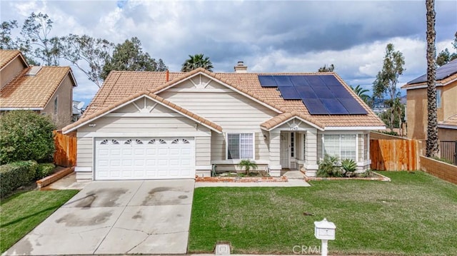 view of front of home with fence, driveway, a front lawn, a garage, and a tile roof