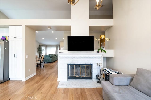 living room with recessed lighting, baseboards, light wood-style flooring, and a fireplace