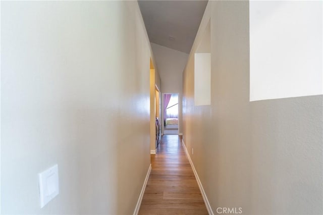 corridor with light wood-style flooring and baseboards