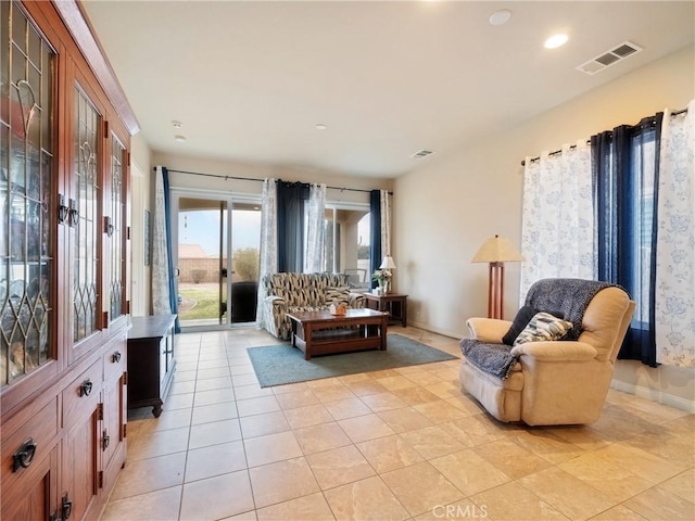 living area featuring light tile patterned flooring, baseboards, and visible vents