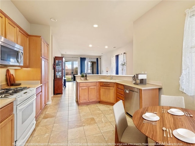 kitchen featuring a sink, light countertops, recessed lighting, and stainless steel appliances