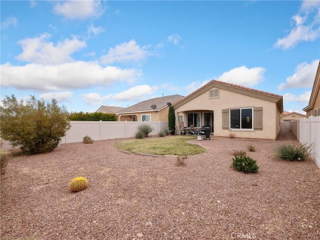 back of property featuring stucco siding, a yard, a fenced backyard, and a patio area