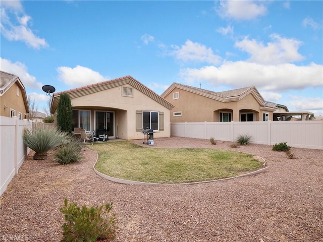 back of property with a patio area, a fenced backyard, a lawn, and stucco siding