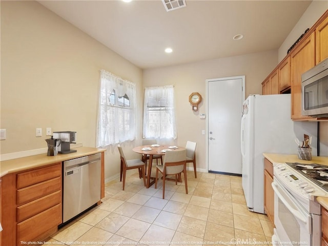 kitchen with light tile patterned floors, baseboards, visible vents, light countertops, and appliances with stainless steel finishes