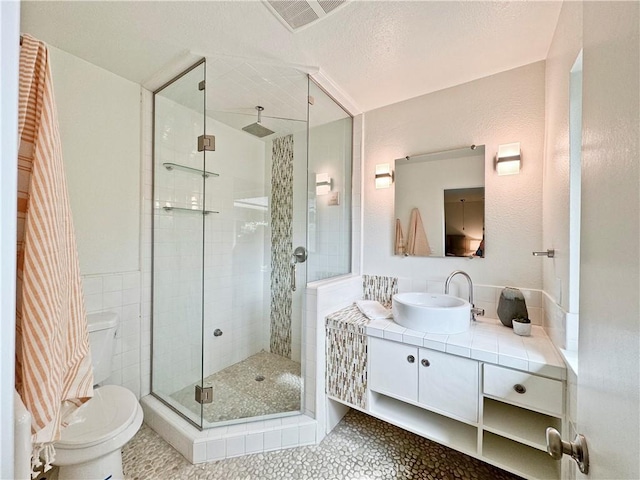 full bathroom with tile patterned flooring, visible vents, toilet, a stall shower, and vanity