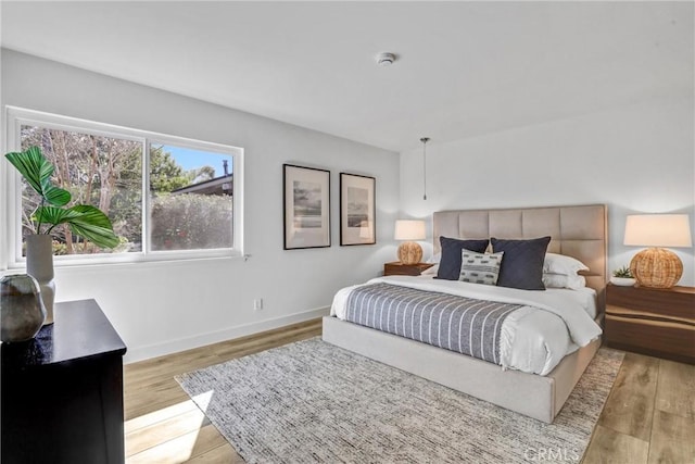 bedroom featuring light wood-style flooring and baseboards