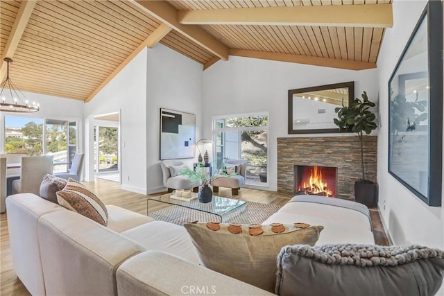 living area with a wealth of natural light, beam ceiling, an inviting chandelier, and wood finished floors