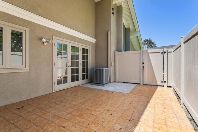 8933 Amador Cir Unit 1316E, Huntington Beach, CA 92646 - view of patio featuring french doors, a gate, central air condition unit, and fence