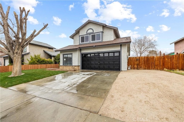 traditional-style home featuring stucco siding, a garage, driveway, and fence