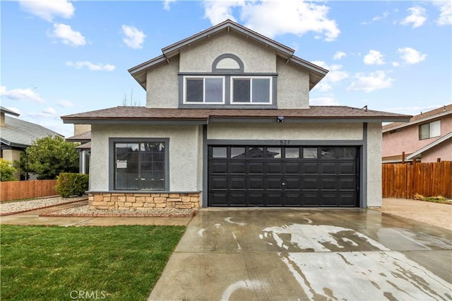 traditional-style house featuring stucco siding, concrete driveway, and fence