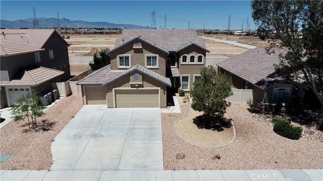 8846 Tamarisk Ave, Hesperia, CA 92344 - view of front facade with stucco siding, a mountain view, driveway, and fence