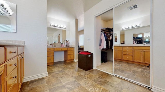 8846 Tamarisk Ave, Hesperia, CA 92344 - full bathroom with baseboards, vanity, a spacious closet, and stone finish floors