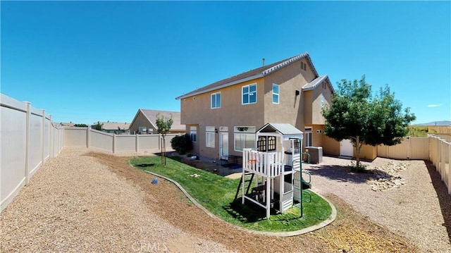 8846 Tamarisk Ave, Hesperia, CA 92344 - back of house featuring cooling unit, a fenced backyard, stucco siding, and a playground