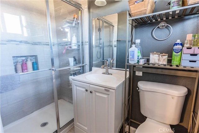 full bathroom featuring vanity, a shower stall, toilet, and a textured wall