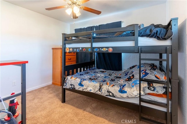 carpeted bedroom with ceiling fan and baseboards