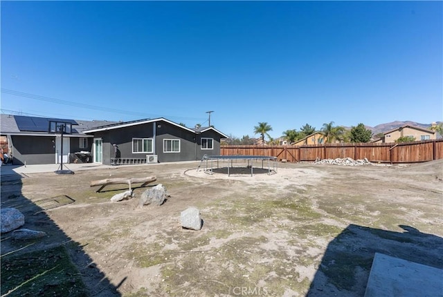 view of yard featuring a patio, a trampoline, and fence