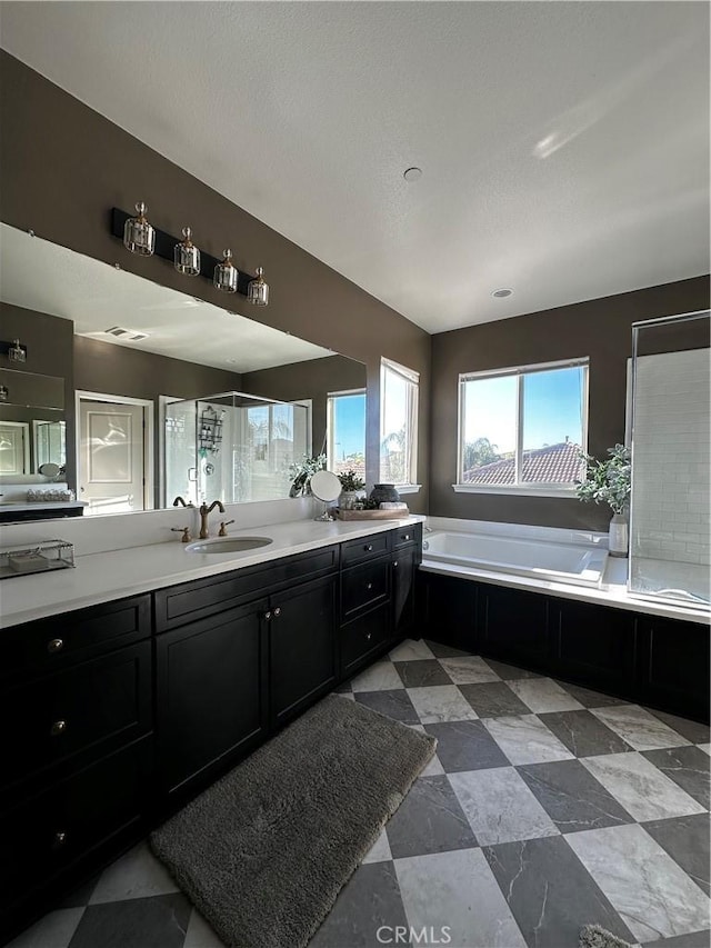 bathroom featuring double vanity, a stall shower, a sink, tile patterned floors, and a bath