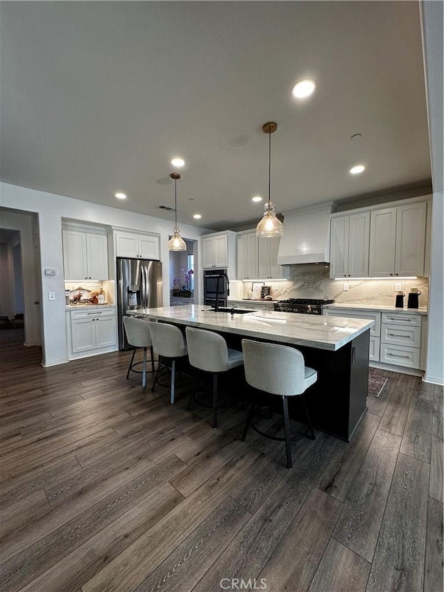 kitchen with dark wood-type flooring, stainless steel refrigerator with ice dispenser, custom range hood, a spacious island, and white cabinetry