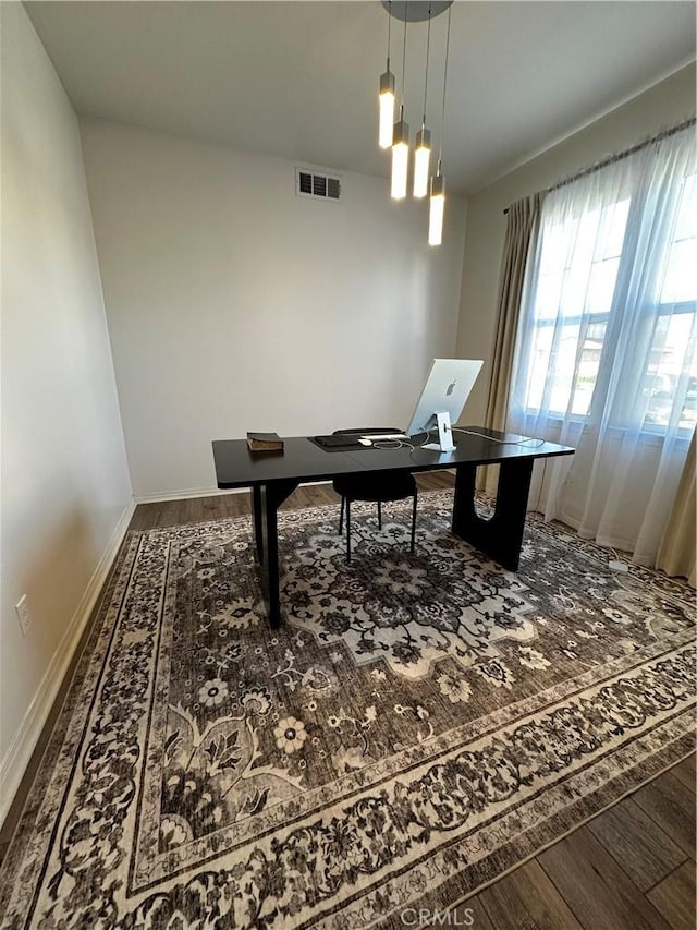 office area featuring visible vents, baseboards, and wood finished floors