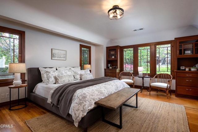 bedroom with light wood-type flooring and visible vents