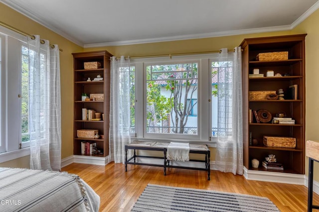 bedroom with baseboards, light wood-type flooring, and ornamental molding