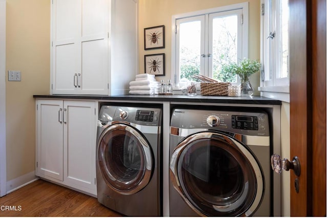 washroom with cabinet space, separate washer and dryer, and wood finished floors