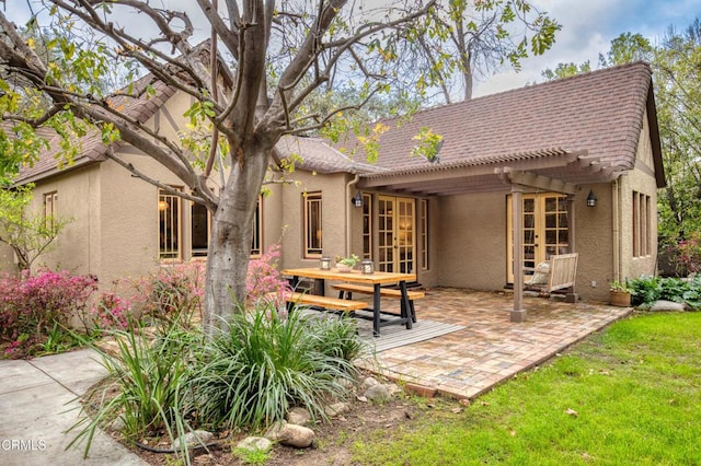 rear view of house featuring stucco siding, french doors, a pergola, and a patio