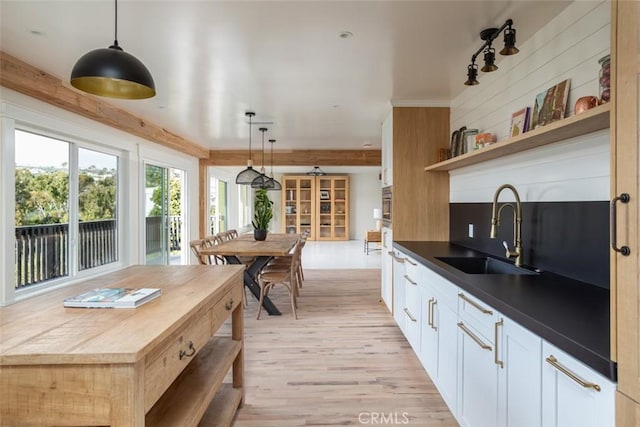 236 Avenida Montalvo, San Clemente, CA 92672 - kitchen with light wood-style flooring, dark countertops, open shelves, hanging light fixtures, and white cabinetry