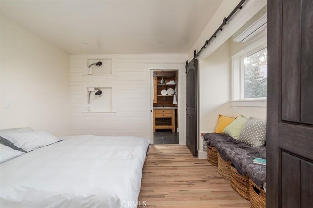 236 Avenida Montalvo, San Clemente, CA 92672 - bedroom with a barn door, light wood finished floors, and ensuite bathroom