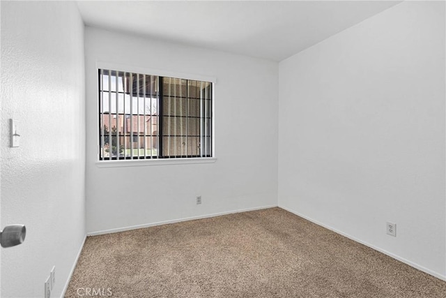 carpeted empty room with baseboards