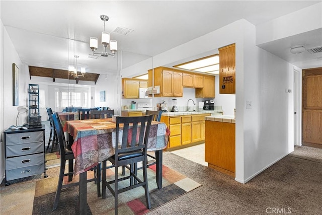 dining space featuring baseboards, light colored carpet, visible vents, and a chandelier