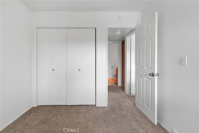 unfurnished bedroom with a closet and carpet floors