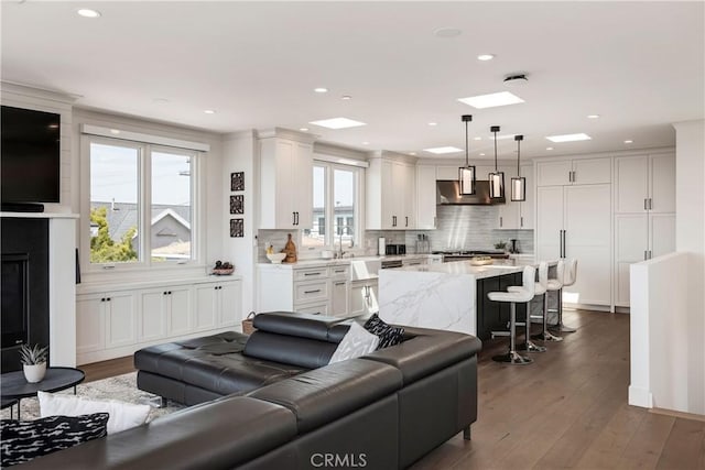 living area with recessed lighting and dark wood-style flooring