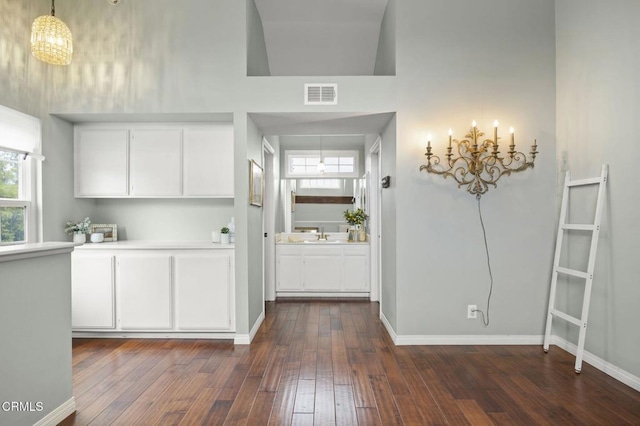 kitchen featuring visible vents, white cabinets, light countertops, and dark wood-style flooring