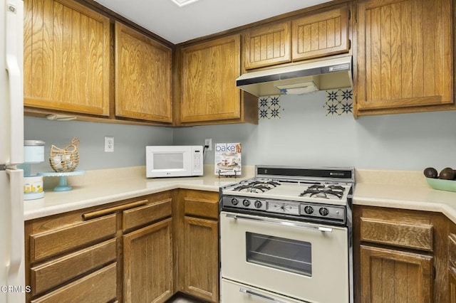 kitchen featuring white appliances, light countertops, and under cabinet range hood