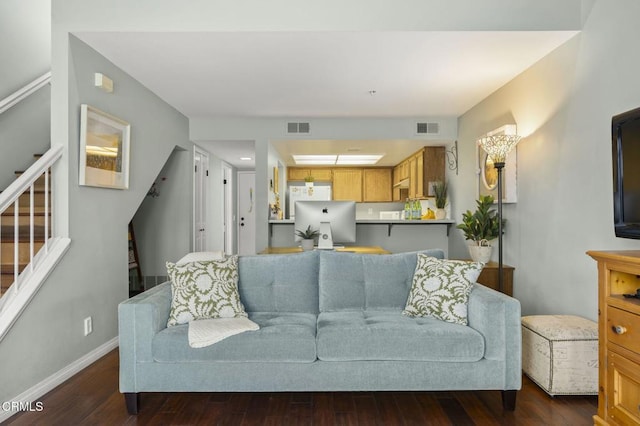 living room featuring visible vents, baseboards, dark wood-style flooring, and stairway