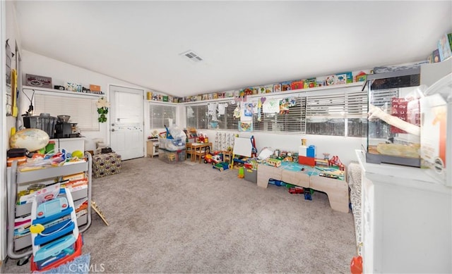 playroom with visible vents, lofted ceiling, and carpet flooring