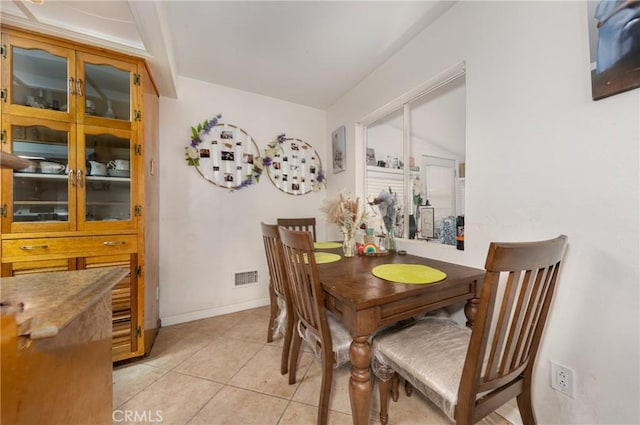 dining area featuring light tile patterned flooring, baseboards, and visible vents