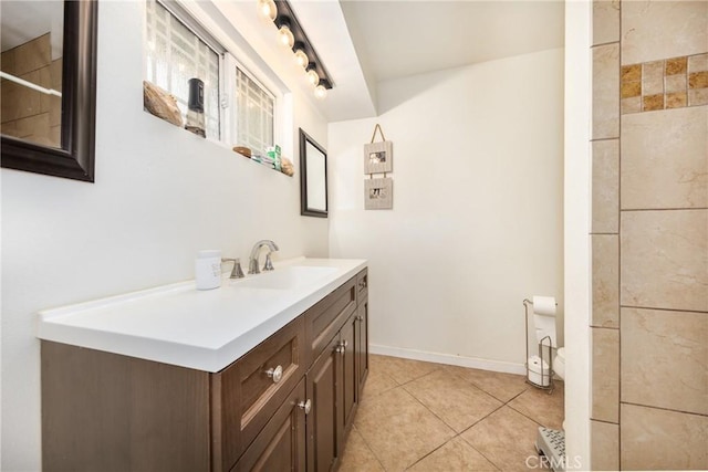 full bathroom with vanity, baseboards, rail lighting, tile patterned floors, and toilet