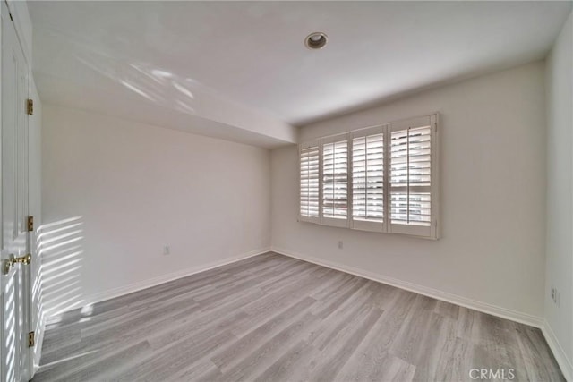 unfurnished room with wood finished floors and baseboards