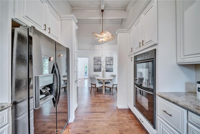 kitchen featuring beam ceiling, light wood-style flooring, white cabinetry, and black appliances