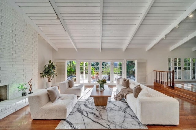 living room featuring french doors, beam ceiling, wood finished floors, and rail lighting