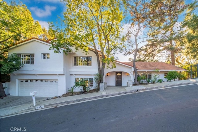 view of front of property featuring stucco siding, driveway, and a garage