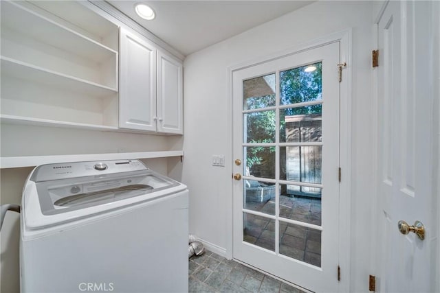 clothes washing area with cabinet space, washer / clothes dryer, and baseboards