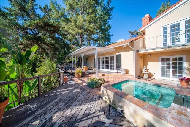 exterior space featuring an in ground hot tub and a wooden deck