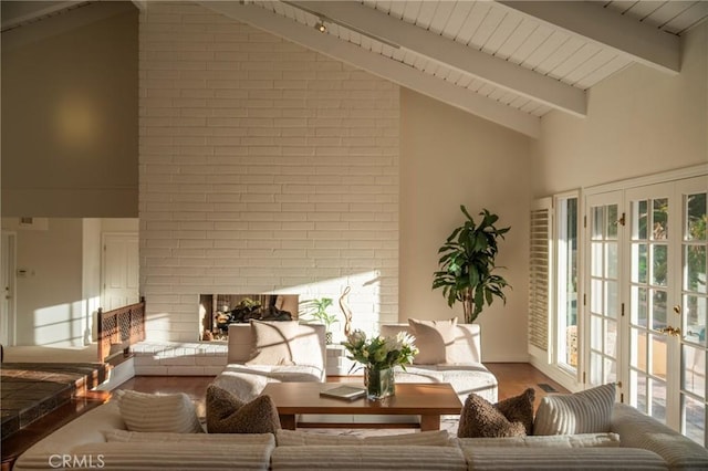 interior space featuring a fireplace, beamed ceiling, wood finished floors, and high vaulted ceiling