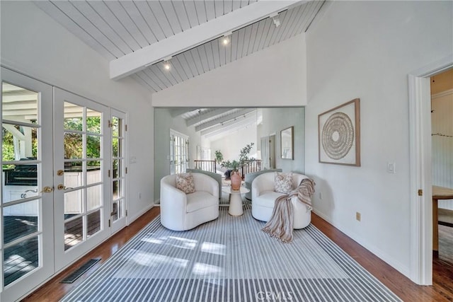 sitting room with lofted ceiling with beams, wood finished floors, visible vents, and french doors