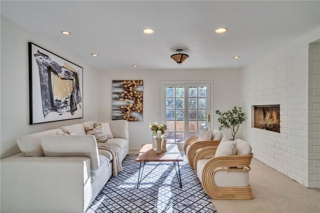 sitting room featuring recessed lighting, light colored carpet, and a brick fireplace